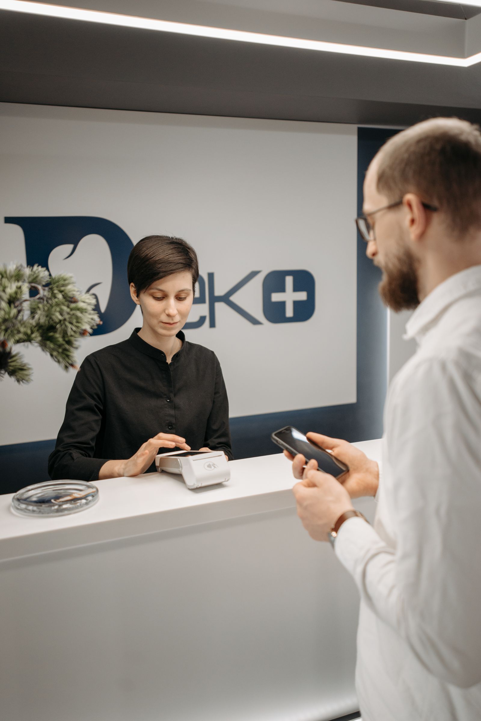 Patient paying contactless at the reception of a modern practice