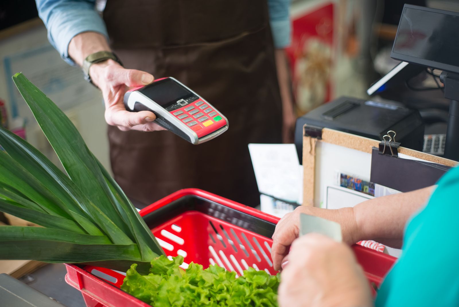 Cashier handing over the card terminal at a supermarket checkout