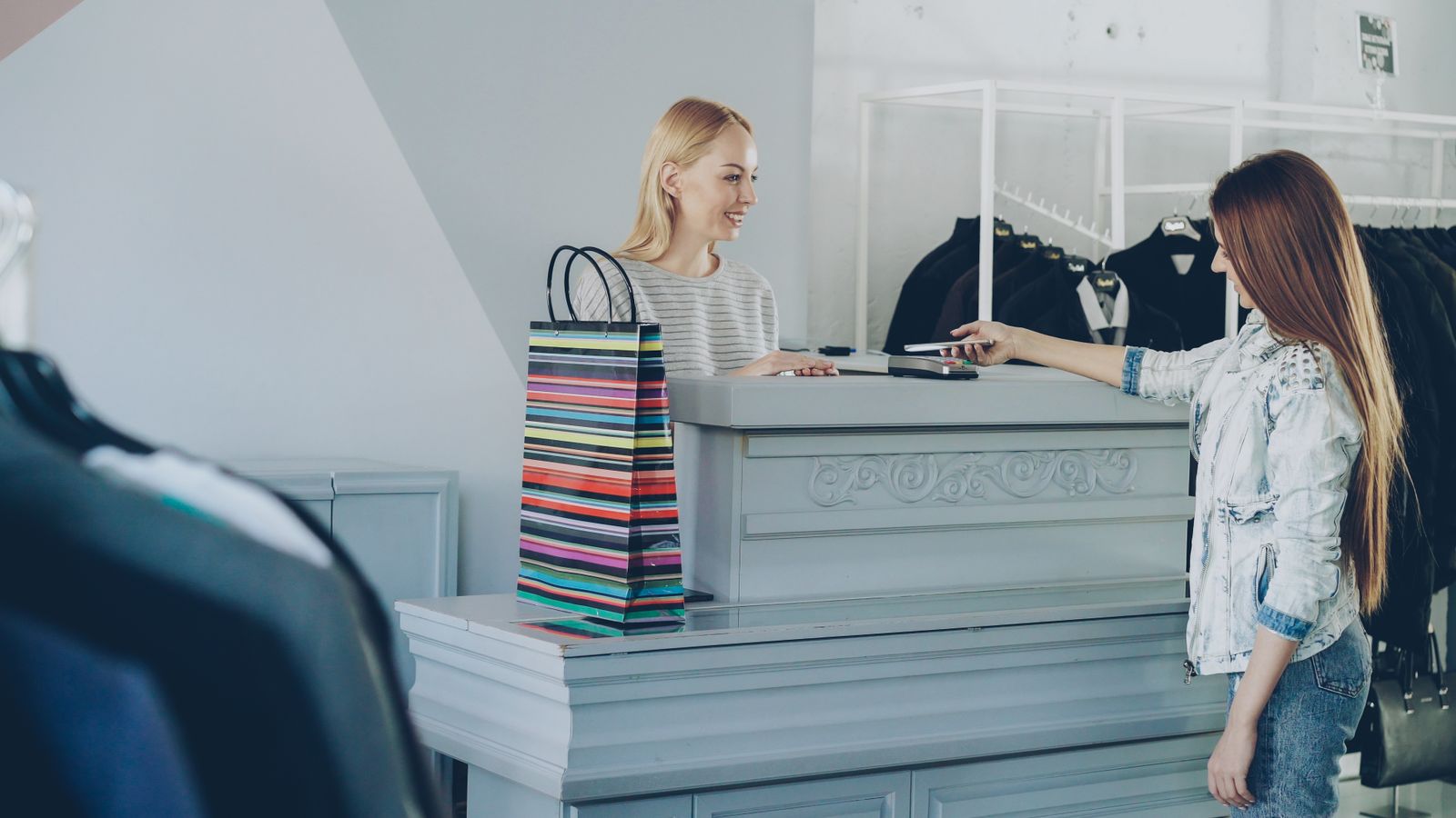Customer paying by card at the register of a fashion boutique